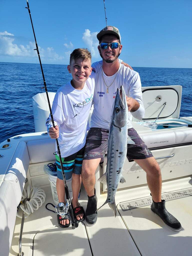 Family fishing catching big barracudas