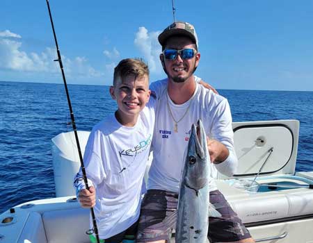 Family fishing catching big barracudas